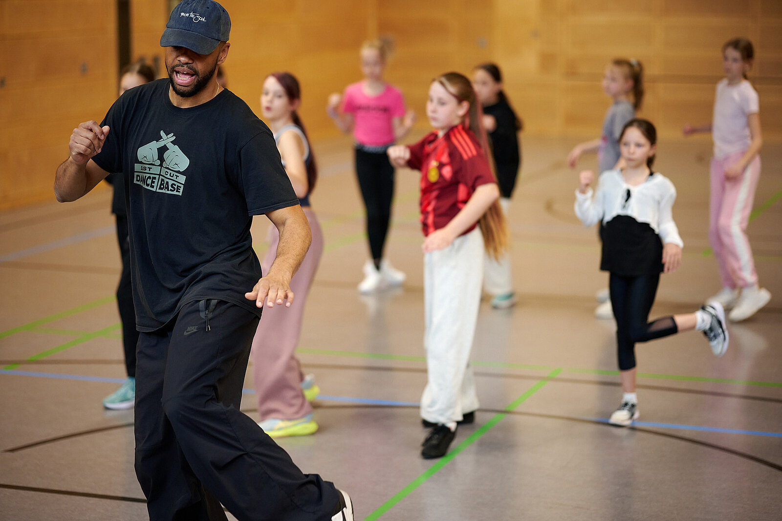 Jugendliche beim Tanzen mit Trainer im Vordergrund